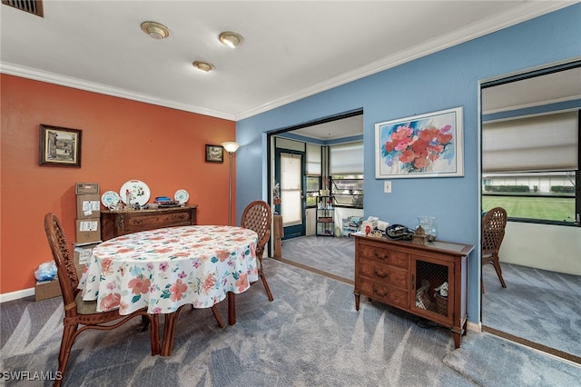 carpeted dining space with ornamental molding