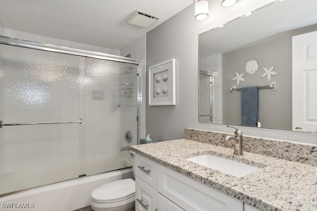 full bathroom featuring vanity, toilet, and enclosed tub / shower combo