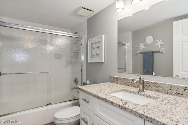 full bathroom with toilet, vanity, and shower / bath combination with glass door