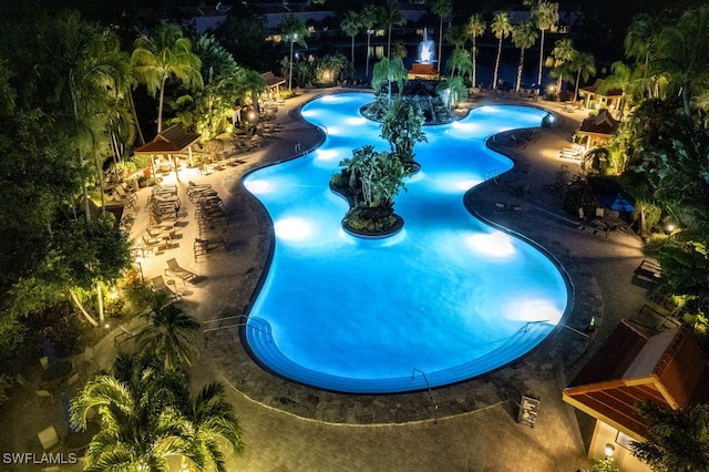 pool at night with a patio area