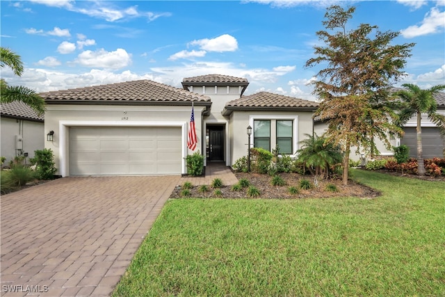 mediterranean / spanish-style home featuring a front yard and a garage