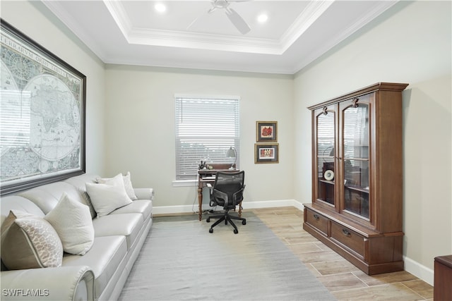 office featuring a raised ceiling, light hardwood / wood-style flooring, crown molding, and ceiling fan