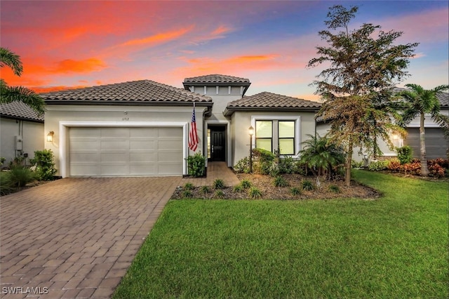 mediterranean / spanish-style home with a garage and a lawn