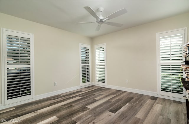 spare room featuring dark wood-type flooring and ceiling fan