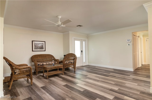 living area with ornamental molding and hardwood / wood-style floors