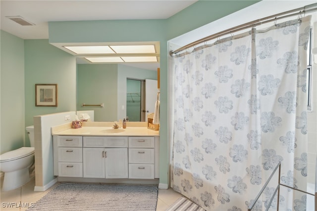 bathroom with toilet, walk in shower, vanity, and tile patterned floors