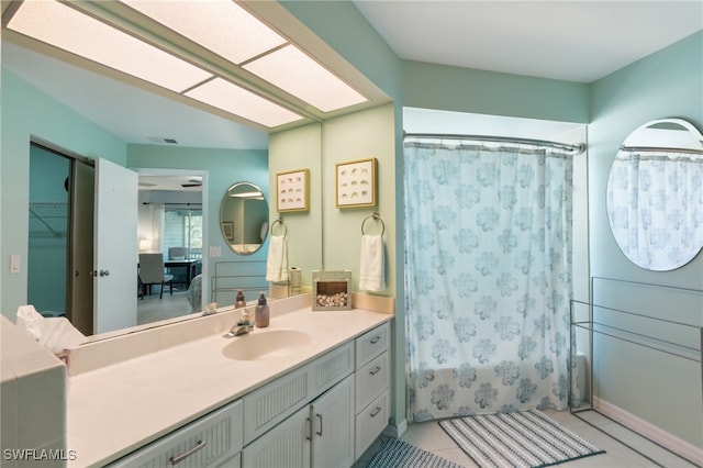 bathroom with vanity, shower / bath combo with shower curtain, and tile patterned flooring