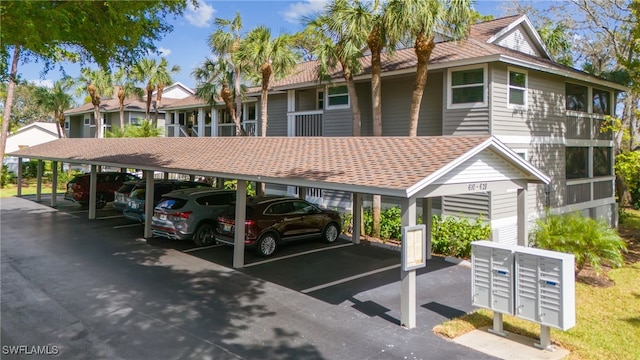 view of vehicle parking with a mail area and a carport