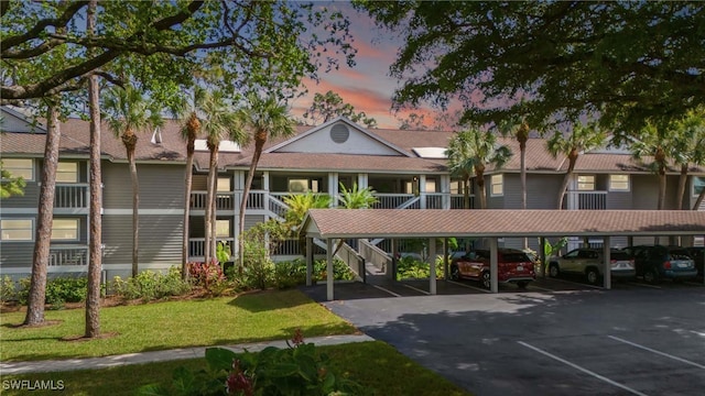 view of building exterior featuring covered parking and stairway