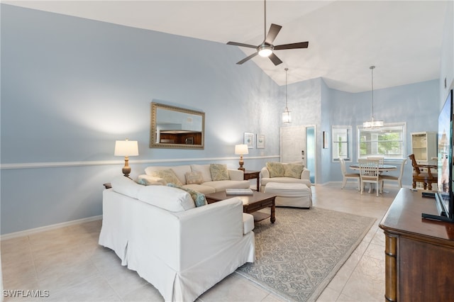 living room featuring light tile patterned flooring, high vaulted ceiling, and ceiling fan with notable chandelier