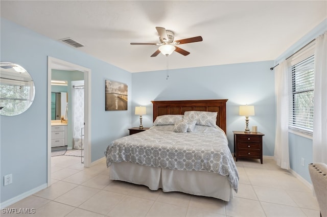 bedroom featuring ensuite bath, light tile patterned flooring, and ceiling fan