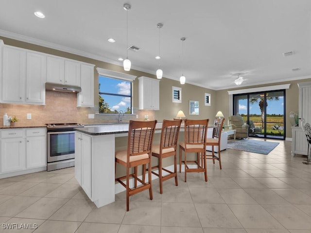 kitchen featuring white cabinetry, a wealth of natural light, decorative light fixtures, and stainless steel range