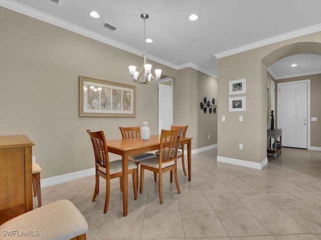 tiled dining space featuring crown molding and a notable chandelier