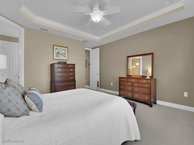 carpeted bedroom with ceiling fan, a raised ceiling, and ornamental molding