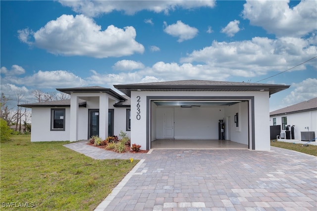 view of front of home featuring water heater, cooling unit, a front lawn, and a garage