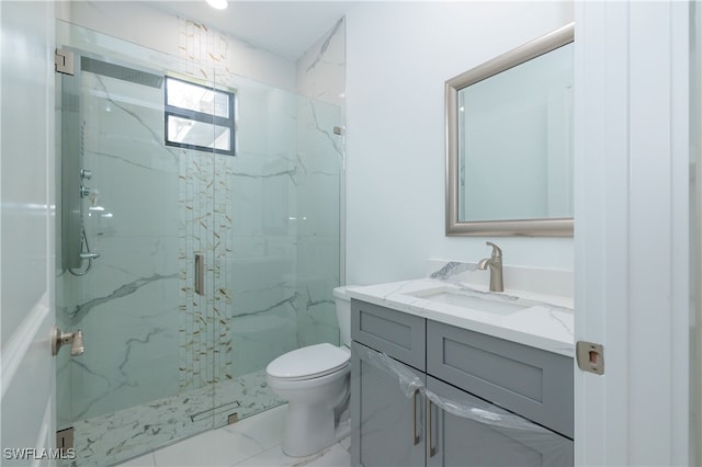 bathroom with vanity, a shower with shower door, and toilet