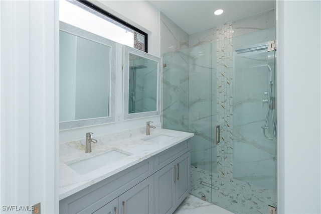 bathroom featuring a shower with door and vanity