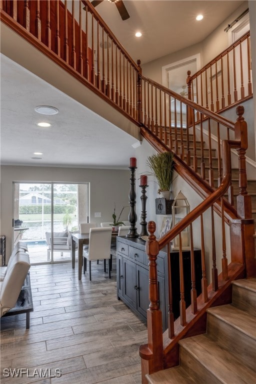 stairs featuring wood-type flooring and ceiling fan