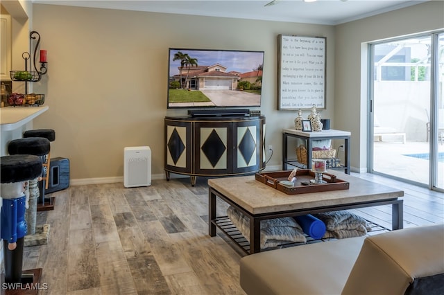 sitting room with crown molding and light hardwood / wood-style flooring