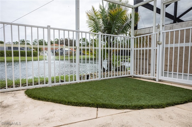 view of gate featuring a water view and a lawn