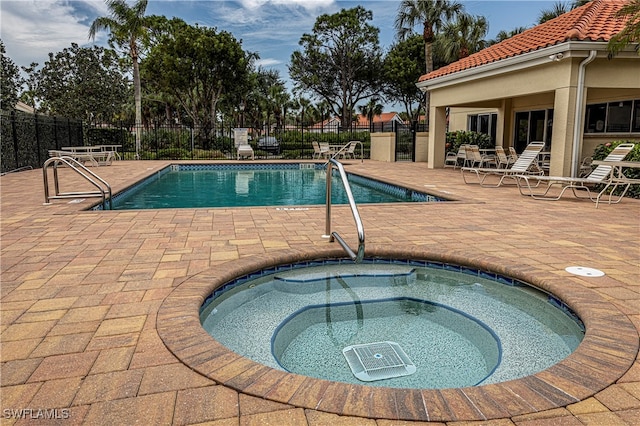 view of swimming pool with a community hot tub and a patio