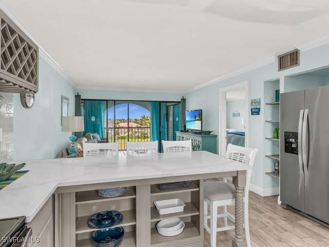 kitchen featuring light stone counters, ornamental molding, stainless steel appliances, and light wood-type flooring