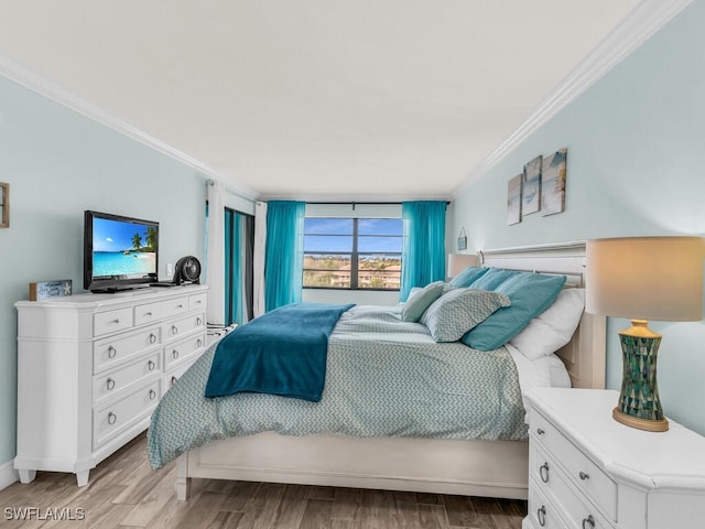 bedroom featuring crown molding and light wood-style floors