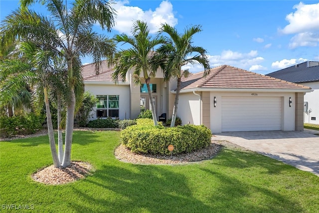 mediterranean / spanish house featuring a front lawn and a garage