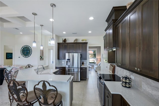 kitchen featuring tasteful backsplash, appliances with stainless steel finishes, sink, dark brown cabinetry, and decorative light fixtures