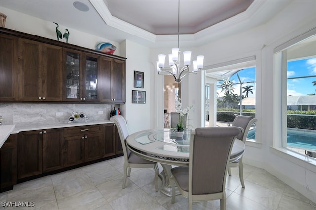 dining space with a notable chandelier, light tile patterned flooring, and a raised ceiling