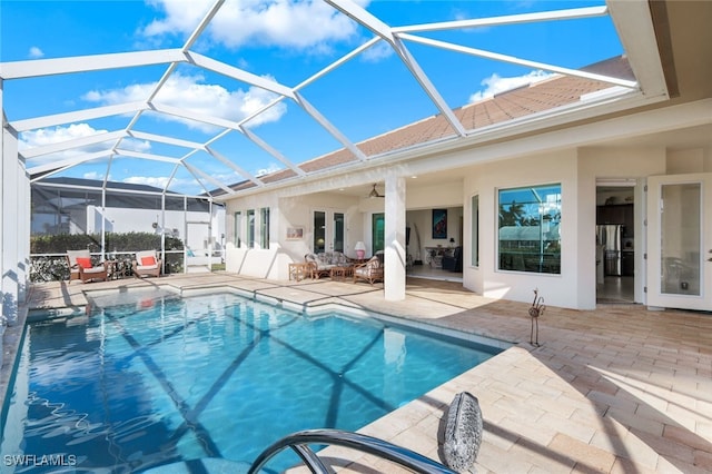 view of swimming pool featuring a patio, ceiling fan, and glass enclosure