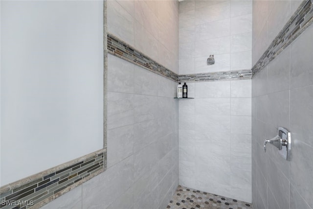 bathroom featuring a tile shower and tile walls