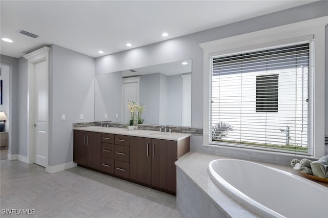 bathroom featuring vanity, tiled bath, and tile patterned floors