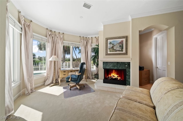 living area featuring light carpet, ornamental molding, and a fireplace