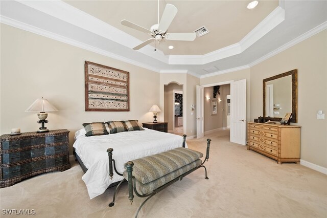 carpeted bedroom featuring ceiling fan, crown molding, and a tray ceiling