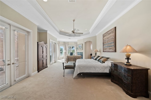 carpeted bedroom featuring ceiling fan, a tray ceiling, ornamental molding, and access to outside