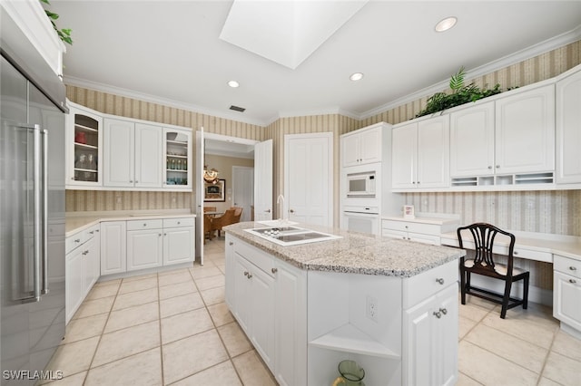 kitchen with white appliances, white cabinets, ornamental molding, and a kitchen island