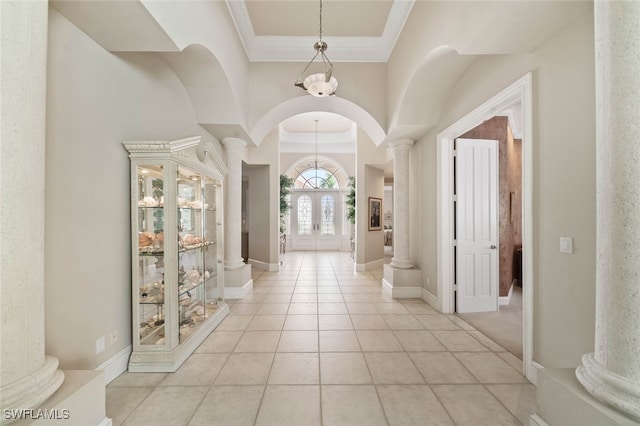 tiled foyer entrance featuring decorative columns and crown molding