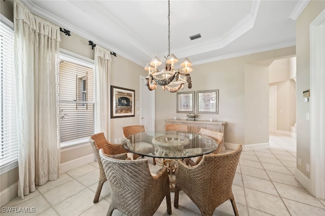 tiled dining space featuring crown molding, a raised ceiling, and a chandelier