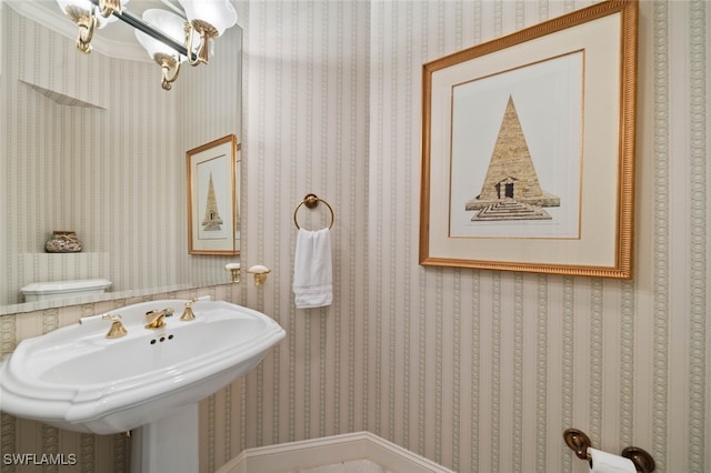 bathroom with sink, toilet, crown molding, and a chandelier