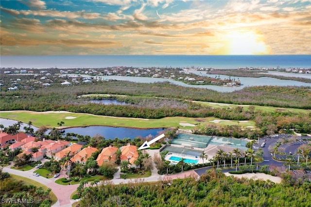 aerial view at dusk featuring a water view