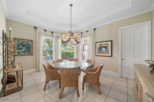 tiled dining room featuring a raised ceiling, an inviting chandelier, and crown molding