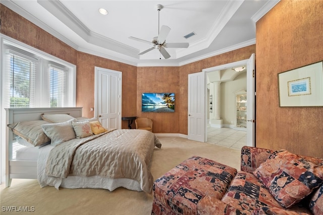 carpeted bedroom featuring ceiling fan, ornamental molding, and a raised ceiling