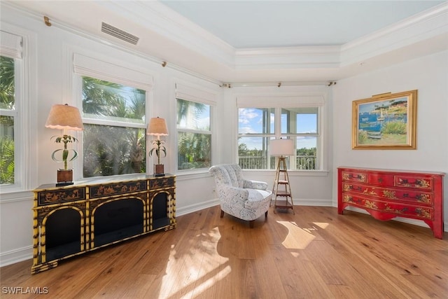 living area with a wealth of natural light, crown molding, and wood-type flooring