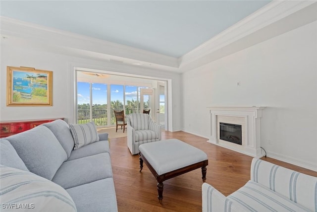 living room featuring light wood-type flooring, crown molding, and a premium fireplace