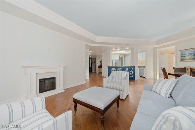 living room with light wood-type flooring and crown molding