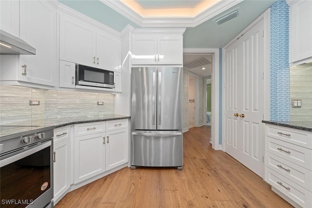 kitchen with white cabinets, light wood-type flooring, and appliances with stainless steel finishes