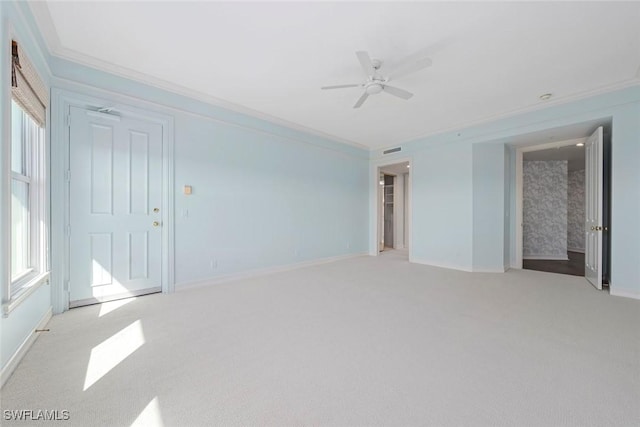 carpeted spare room featuring ceiling fan and crown molding