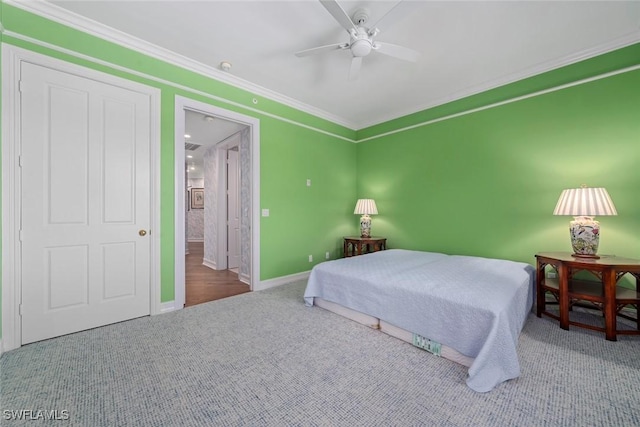 bedroom with ceiling fan, carpet floors, ensuite bathroom, and ornamental molding