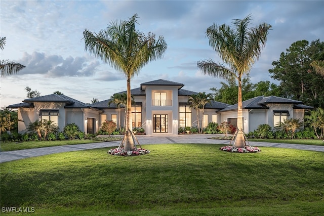 view of front of house with a garage, french doors, and a front lawn